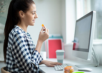 femme qui mange des abricots secs en travaillant