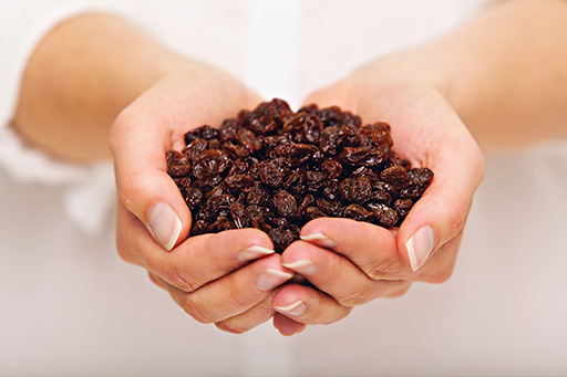 raisins secs dans deux mains